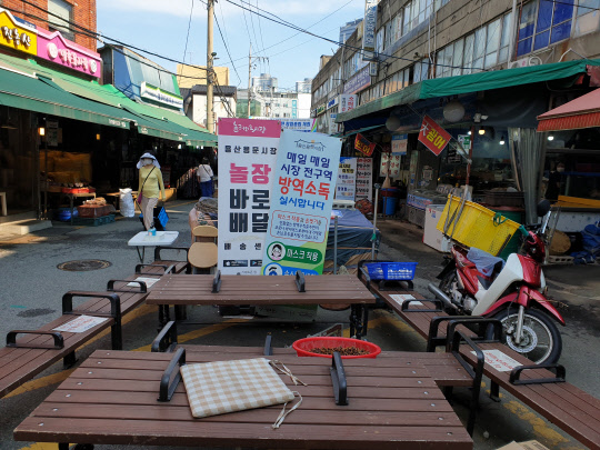 지난 23일 낮에 방문한 용산 용문시장. 시장 초입에 매일 시장 전구역에 대한 방역·소독을 실시한다는 문구가 적혀있고 손소독제가 놓여있지만 벤치에 앉아있는 사람을 찾아보기는 어려웠다. 무더운 날씨와 고강도 사회적 거리두기 적용에 주민들이 불안감을 느꼈기 때문으로 보인다. 디지털타임스 임재섭 기자.